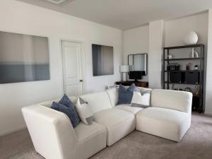 a living room with a white couch and blue pillows at Spacious 4BR Oasis - Pool - Patio - 8 Min to Kalahari in Round Rock