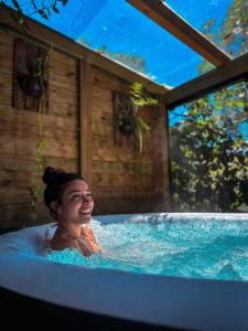 a woman in a jacuzzi tub in at Pousada Vale da Magia in Praia do Rosa