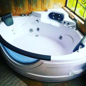 - une baignoire blanche dans une chambre avec fenêtre dans l'établissement Freestyle House Hostel, à Lligua