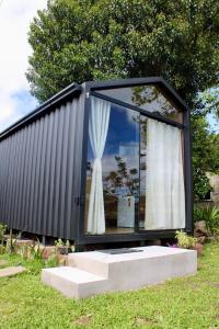 ein schwarzer Container mit einem Fenster im Gras in der Unterkunft Premium Black in Canela
