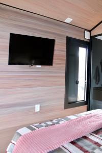 ein Schlafzimmer mit einem Flachbildfernseher an der Wand in der Unterkunft Premium Black in Canela