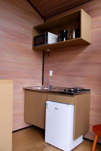 eine kleine Küche mit Spüle und Kühlschrank in der Unterkunft Premium Black in Canela