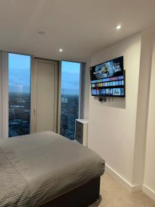 a bedroom with a bed and a flat screen tv at Modern 2 Bed Penthouse with Stunning views in Manchester City Center in Manchester +15 photos