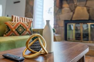 a wooden table with a vase and a remote control at Heritage Haus - Luxe 2BR w Deck, Pets OK, Wi-fi, Near Marietta Sq in Marietta