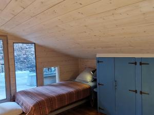 a bedroom in a cabin with a bed and a window at Maison cosy avec cour privative au cœur de l'Auvergne - FR-1-582-316 in Lempdes sur Allagnon