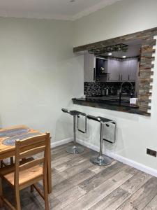 a kitchen with a table and two bar stools at Charming Aldershot Home - Free Parking in Ash