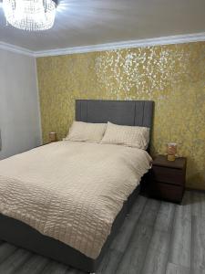 a bedroom with a bed and a wall with flowers at Charming Aldershot Home - Free Parking in Ash