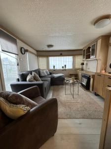 ein Wohnzimmer mit Sofa und Tisch in der Unterkunft Tiny Beach Cottage - New Vennepark Wenduine in De Haan