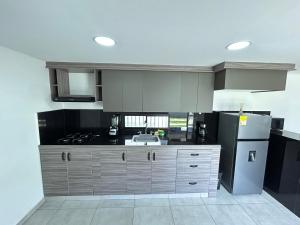 a kitchen with a sink and a refrigerator at House 10 minutes from the airport, Rionegro in Rionegro
