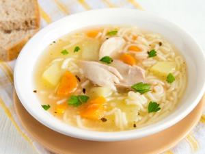 a bowl of chicken noodle soup on a plate with bread at Hotel GM Double bed Zamora chinchipe in Zamora +23 photos