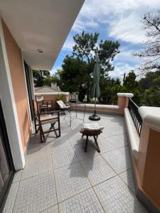 a patio with a bench and an umbrella on a balcony at Apart en playa hermosa piriapolis a dos cuadras de la playa in Piriápolis