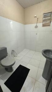 a bathroom with a toilet and a sink at Casa Laranja in Presidente Figueiredo
