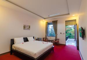 a bedroom with a bed and a table and a window at Thuy Loi Hotel in Hoi An