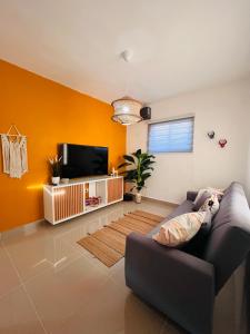 a living room with a couch and a tv at Boho Vibes Punta Cana in Punta Cana +8 photos