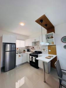 a kitchen with white cabinets and a stainless steel refrigerator at Boho Vibes Punta Cana in Punta Cana