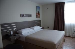 a hotel room with a bed and a window at Alto del Sol Plaza Mejillones in Mejillones