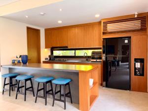 ジンバランにあるCana Villa Jimbaranのキッチン(青いバースツール付きの大きなカウンター付)
