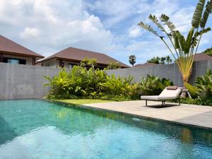 ジンバランにあるCana Villa Jimbaranのスイミングプールの横に椅子