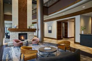 a lobby with chairs tables and a fireplace at Denver Marriott South at Park Meadows in Lone Tree