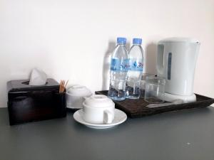 a tray with a coffee maker and bottles of water at Sokha Home in Bahal