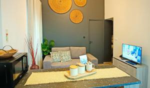 sala de estar con sofá y mesa con tazas en HomeLand Place AL, en Horta 2 fotos más