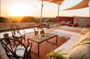 a patio with a table and chairs and an umbrella at Villa Lala Argana in Essaouira