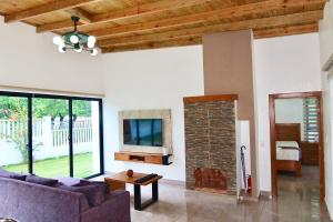 a living room with a couch and a tv at Villa Plasencia! in El Tetero