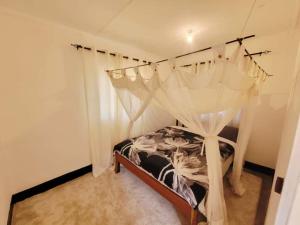 une chambre avec un lit à baldaquin dans l'établissement The Silken Oak, à Kasama