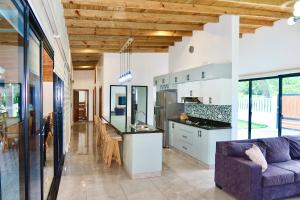 an open kitchen and living room with a purple couch at Villa Plasencia! in El Tetero