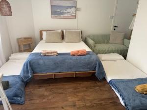 a bedroom with a large bed and a couch at Byron Bay Sunrise Studio in Byron Bay