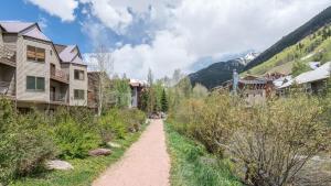 a dirt path through a village with houses and mountains at Viking Lodge 117 by AvantStay Ski Home Near Town Park Downtown in Telluride