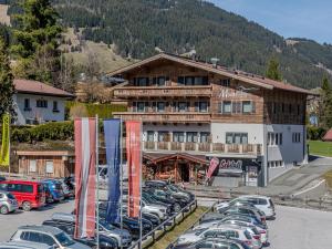 a parking lot with cars parked in front of a building at Nice apartment in Jochberg with ski-in, out in Jochberg