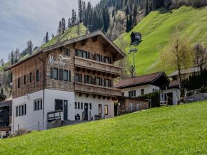 a building on a hill with a grassy hill at Apartment with ski-storage, parking in Jochberg