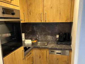 a kitchen with wooden cabinets and a sink at Apartment 20 m from Jochberg ski lift in Jochberg
