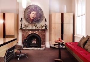 a living room with a fireplace and a fireplace mantel at Medusa Hotel Sydney in Sydney