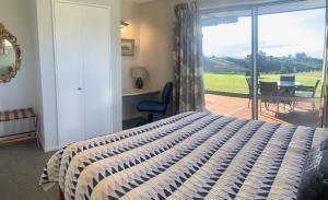 een slaapkamer met een bed en uitzicht op een patio bij Mapua - Rural bliss in Tasman