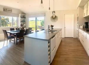 een keuken met een groot eiland en een eetkamer bij Mapua - Rural bliss in Tasman +11 foto's