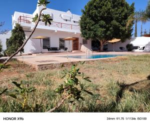 a house with a swimming pool next to a yard at Ferme d'hôtes Aghbalou in Sefrou