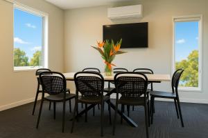 a dining room with a table and chairs and a tv at Avenue WEST Studio Units in Toowoomba