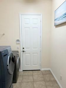 a white door in a room with a washing machine at Quiet Naples retreat suite with pool - 1 or 2 bedrooms in Naples
