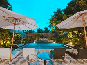a swimming pool with chairs and umbrellas at Angkor Rise Residence in Siem Reap