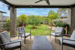 a patio with four chairs and a garden at Stylish Coastal Retreat in Ocean Grove