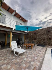 圣玛尔塔Casa Mariana Hostel Boutique的一个带桌子和蓝伞的庭院