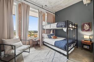 ein Schlafzimmer mit einem Etagenbett und einem Stuhl in der Unterkunft Stylish Vintage Loft in Dallas + 39 Fotos