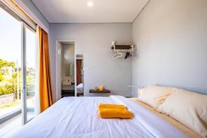 ein Schlafzimmer mit einem großen Bett und einem gelben Handtuch darauf in der Unterkunft 2BR Sun Flower Home in Uluwatu