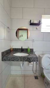 Un baño con lavabo, espejo e inodoro. en AP Novo, Bem Localizado, Ar-Condicionado, en Montes Claros