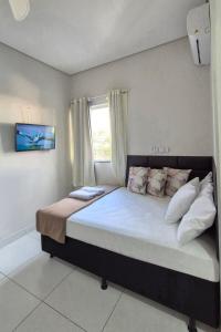 Un dormitorio con una cama grande con ventana. en AP Novo, Bem Localizado, Ar-Condicionado, en Montes Claros