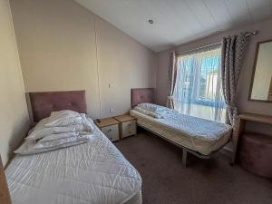 Cette chambre comprend 2 lits et une fenêtre. dans l'établissement Beautiful Lodge With Decking In Hunstanton At Manor Park Ref 23195K, à Hunstanton 21 autres photos
