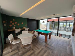 um quarto com uma mesa de bilhar e algumas cadeiras em Tamandaré Mar de Campas Flat 218 Carneiros em Tamandaré