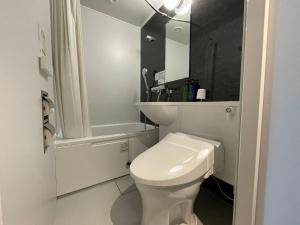 a white bathroom with a toilet and a shower at Business Inn Fukuyama in Fukuyama